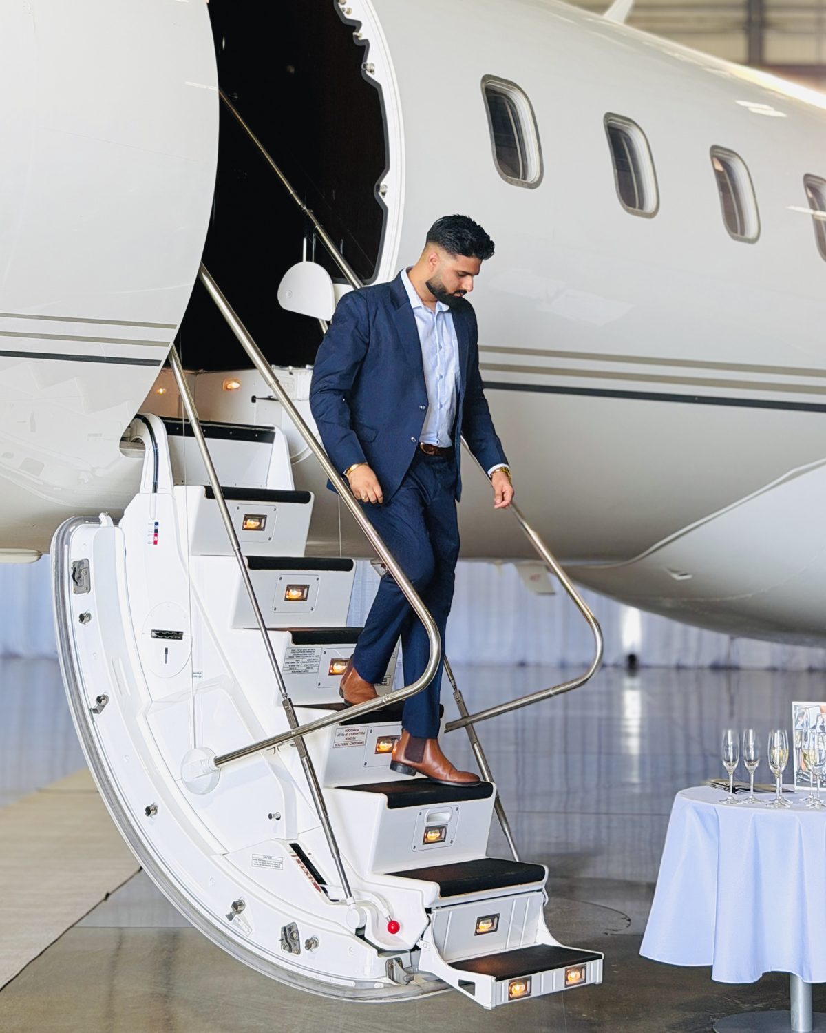 Mohit stepping down the stairs of a private jet